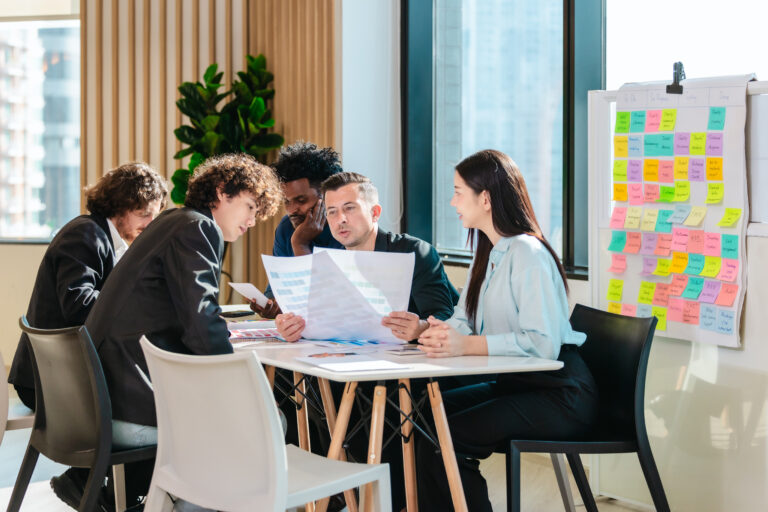 An engineering team planning work next to a board of sticky notes